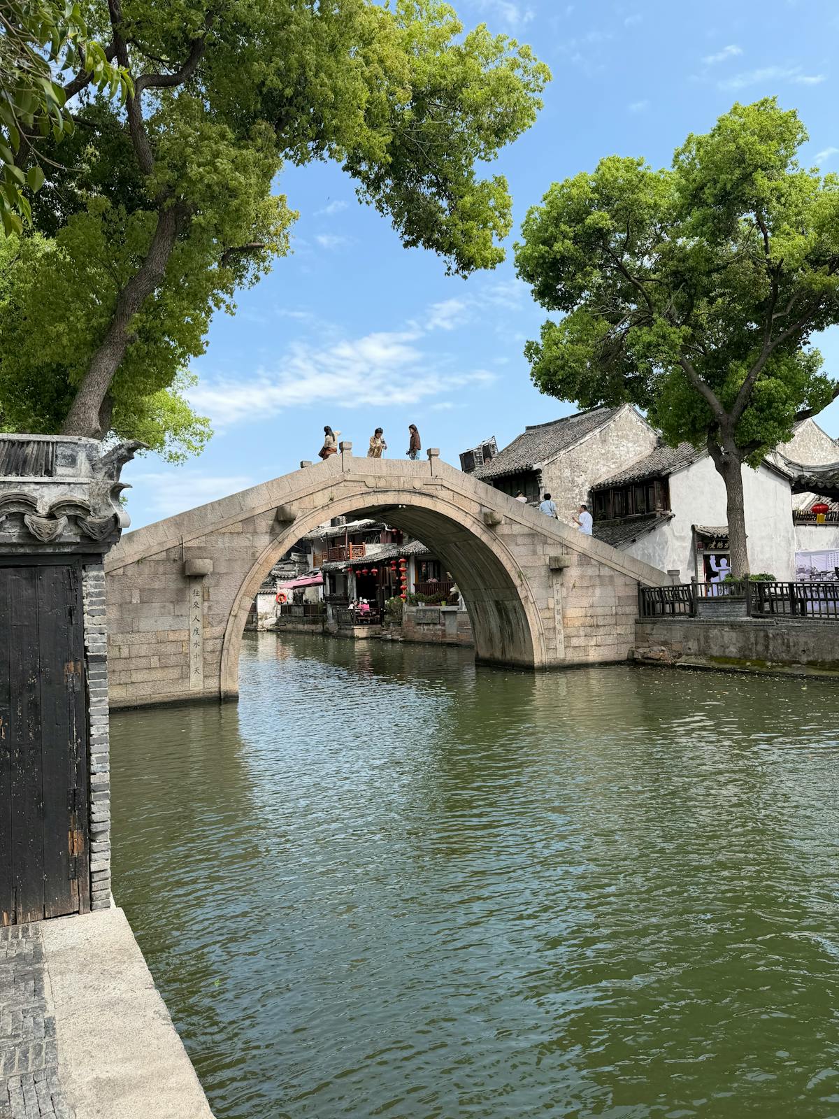 A stone arched bridge over a canal in Zhujiajiao water town with traditional Ming-era buildings